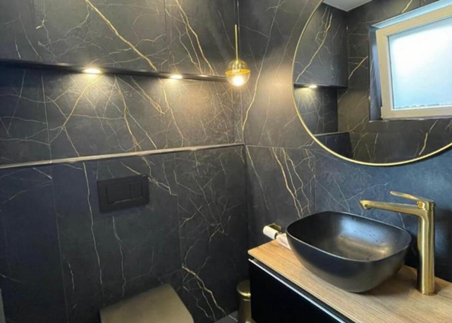 Edles Gäste-WC mit goldenen Armaturen & Accessoires - Schwarze Marmoroptik mit Designer-Aufsatzwaschbecken und LED-Beleuchtung
